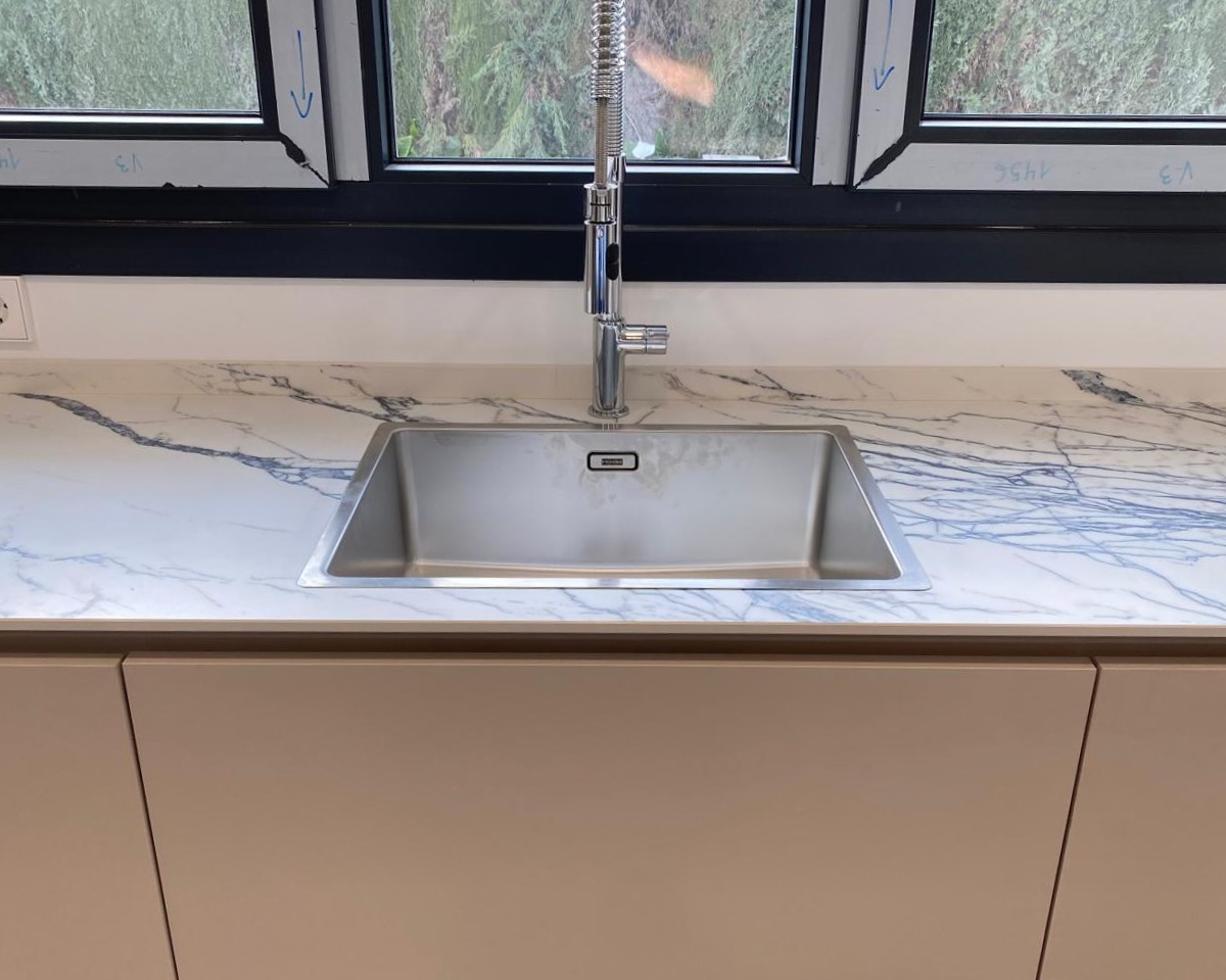 Fregadero de acero inoxidable sobre encimera de madera natural